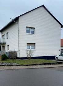 Dieselbe Fassade sauber und weiß nach der Sanierung