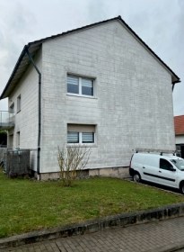 Verwitterte helle Fassade eines Zweifamilienhauses